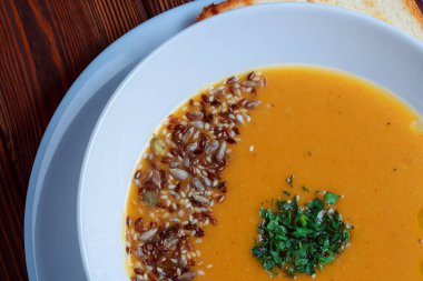 Tahta tepside ekmekle sebze çorbası. Koyu renk tahta arka planda beyaz kase. Üst Manzara. Boşluğu kopyala.