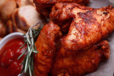 Orijinal et yemeği servisi. Kızarmış tavuk kanadı ve but. Kızarmış peynir topları, ızgara sosis, biberiye ve ketçap. Açık hava yemekleri için yiyecek..