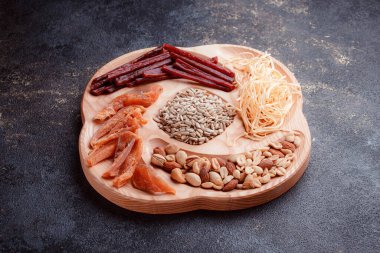 Ahşap çatal üzerinde bira için atıştırmalıklar. Dilimlenmiş balık dilimleri ve sopa şeklinde. Fındık ve peynir karışımı. Koyu dokuda yemek. Çevre dostu sofra takımı.