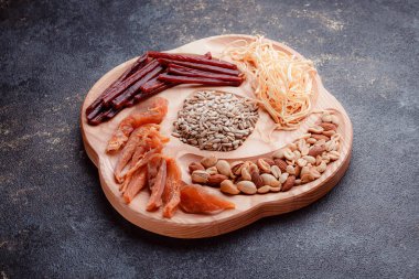 Ahşap çatal üzerinde bira için atıştırmalıklar. Dilimlenmiş balık dilimleri ve sopa şeklinde. Fındık ve peynir karışımı. Koyu dokuda yemek. Çevre dostu sofra takımı.