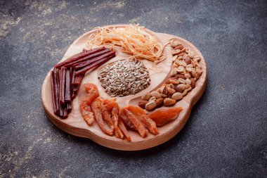 Ahşap çatal üzerinde bira için atıştırmalıklar. Dilimlenmiş balık dilimleri ve sopa şeklinde. Fındık ve peynir karışımı. Koyu dokuda yemek. Çevre dostu sofra takımı.