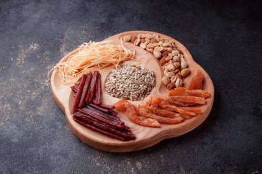 Ahşap çatal üzerinde bira için atıştırmalıklar. Dilimlenmiş balık dilimleri ve sopa şeklinde. Fındık ve peynir karışımı. Koyu dokuda yemek. Çevre dostu sofra takımı.