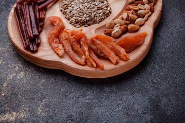 Ahşap çatal üzerinde bira için atıştırmalıklar. Dilimlenmiş balık dilimleri ve sopa şeklinde. Fındık ve peynir karışımı. Koyu dokuda yemek. Çevre dostu sofra takımı.