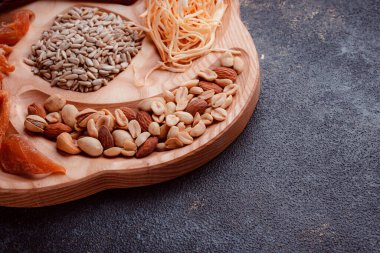 Ahşap çatal üzerinde bira için atıştırmalıklar. Dilimlenmiş balık dilimleri ve sopa şeklinde. Fındık ve peynir karışımı. Koyu dokuda yemek. Çevre dostu sofra takımı.