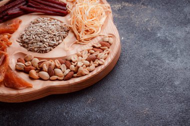 Ahşap çatal üzerinde bira için atıştırmalıklar. Dilimlenmiş balık dilimleri ve sopa şeklinde. Fındık ve peynir karışımı. Koyu dokuda yemek. Çevre dostu sofra takımı.