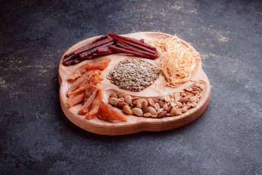 Ahşap çatal üzerinde bira için atıştırmalıklar. Dilimlenmiş balık dilimleri ve sopa şeklinde. Fındık ve peynir karışımı. Koyu dokuda yemek. Çevre dostu sofra takımı.