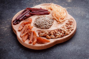 Ahşap çatal üzerinde bira için atıştırmalıklar. Dilimlenmiş balık dilimleri ve sopa şeklinde. Fındık ve peynir karışımı. Koyu dokuda yemek. Çevre dostu sofra takımı.