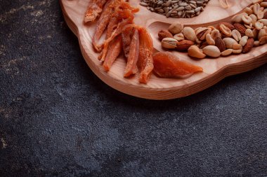 Ahşap çatal üzerinde bira için atıştırmalıklar. Dilimlenmiş balık dilimleri ve sopa şeklinde. Fındık ve peynir karışımı. Koyu dokuda yemek. Çevre dostu sofra takımı.