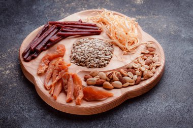 Ahşap çatal üzerinde bira için atıştırmalıklar. Dilimlenmiş balık dilimleri ve sopa şeklinde. Fındık ve peynir karışımı. Koyu dokuda yemek. Çevre dostu sofra takımı.