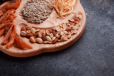 Ahşap çatal üzerinde bira için atıştırmalıklar. Dilimlenmiş balık dilimleri ve sopa şeklinde. Fındık ve peynir karışımı. Koyu dokuda yemek. Çevre dostu sofra takımı.