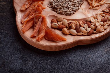 Ahşap çatal üzerinde bira için atıştırmalıklar. Dilimlenmiş balık dilimleri ve sopa şeklinde. Fındık ve peynir karışımı. Koyu dokuda yemek. Çevre dostu sofra takımı.