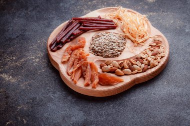 Ahşap çatal üzerinde bira için atıştırmalıklar. Dilimlenmiş balık dilimleri ve sopa şeklinde. Fındık ve peynir karışımı. Koyu dokuda yemek. Çevre dostu sofra takımı.