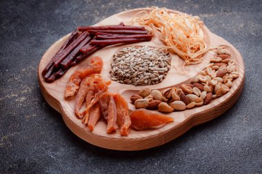 Ahşap çatal üzerinde bira için atıştırmalıklar. Dilimlenmiş balık dilimleri ve sopa şeklinde. Fındık ve peynir karışımı. Koyu dokuda yemek. Çevre dostu sofra takımı.