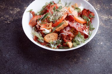 Domatesli panzanella salatası ve taze yeşillikli kağıt. Karanlık masada taze sebze karışımı. Üst Görünüm, Boşluğu Kopyala.