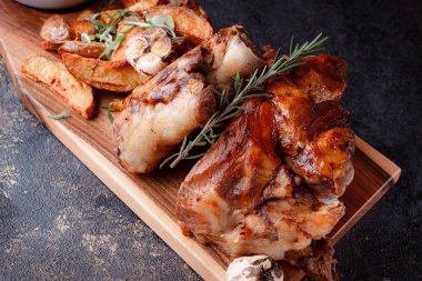 Bir set tabağı: kemiklerde büyük bir parça et, köy usulü ızgara patates, küçük bir lahana salatası, fasulye filizi, chia tohumu ve yeşil soğan. Orijinal servis ahşap kesme tahtasında..