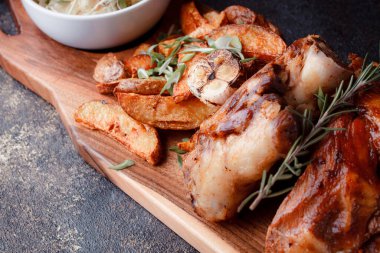 Bir set tabağı: kemiklerde büyük bir parça et, köy usulü ızgara patates, küçük bir lahana salatası, fasulye filizi, chia tohumu ve yeşil soğan. Orijinal servis ahşap kesme tahtasında..