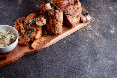 Bir set tabağı: kemiklerde büyük bir parça et, köy usulü ızgara patates, küçük bir lahana salatası, fasulye filizi, chia tohumu ve yeşil soğan. Orijinal servis ahşap kesme tahtasında..