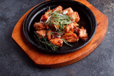 Kızarmış et ve karamelli soslu sıcak tava. Pişmiş ve taze sebzeler garnitür ve garnitür olarak..