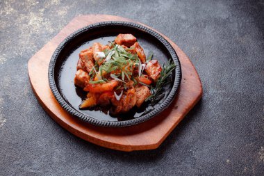 Kızarmış et ve karamelli soslu sıcak tava. Pişmiş ve taze sebzeler garnitür ve garnitür olarak..