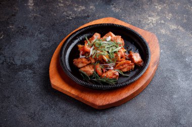 Kızarmış et ve karamelli soslu sıcak tava. Pişmiş ve taze sebzeler garnitür ve garnitür olarak..