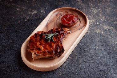 Karamelize soslu ızgara domuz bifteği. Çevre dostu ahşap kaplarda et servisi. Taze biberiye ve domates sosu..