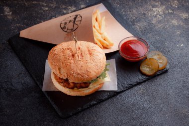 Lezzetli ev yapımı hamburger ızgara et, domates, peynir, salatalık ve ahşap masada sos..