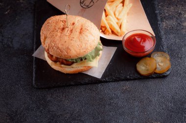 Lezzetli ev yapımı hamburger ızgara et, domates, peynir, salatalık ve ahşap masada sos..