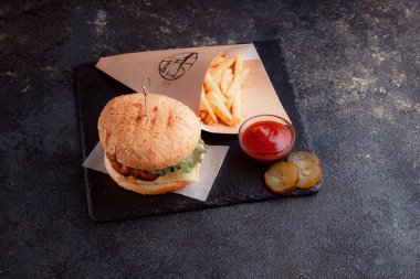 Lezzetli ev yapımı hamburger ızgara et, domates, peynir, salatalık ve ahşap masada sos..