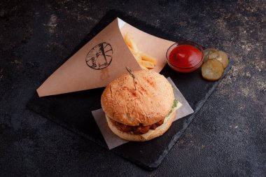 Lezzetli ev yapımı hamburger ızgara et, domates, peynir, salatalık ve ahşap masada sos..