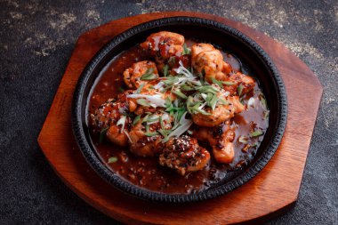 Kızarmış et ve karamelli soslu sıcak tava. Pişirilmiş ve garnitür olarak taze sebzeler. Keten tohumu ve susam tohumu eklenmiş bir yemek..