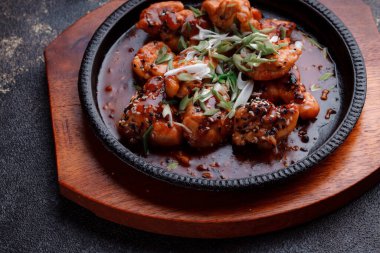 Kızarmış et ve karamelli soslu sıcak tava. Pişirilmiş ve garnitür olarak taze sebzeler. Keten tohumu ve susam tohumu eklenmiş bir yemek..