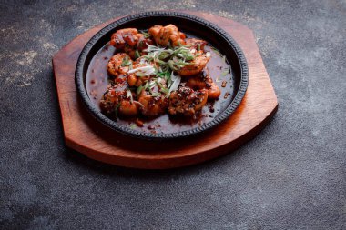 Kızarmış et ve karamelli soslu sıcak tava. Pişirilmiş ve garnitür olarak taze sebzeler. Keten tohumu ve susam tohumu eklenmiş bir yemek..