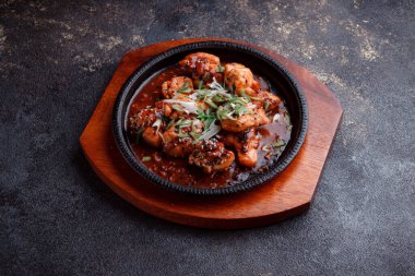 Kızarmış et ve karamelli soslu sıcak tava. Pişirilmiş ve garnitür olarak taze sebzeler. Keten tohumu ve susam tohumu eklenmiş bir yemek..