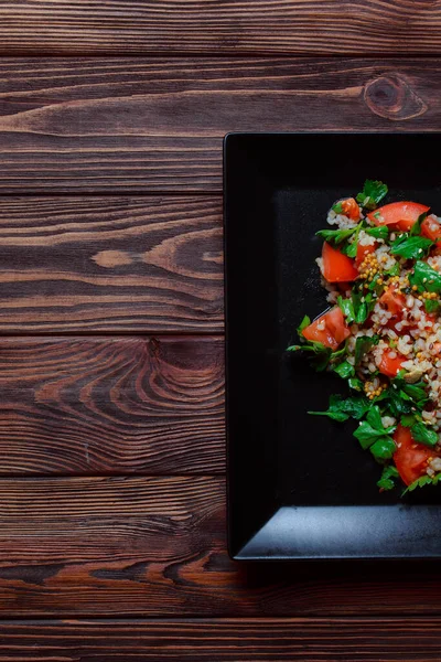 Yeşil yapraklı ve sebzeli salata. Lean vejetaryen yemeği. Hafif salata, domatesli marul, bulgur, maydanoz, baharatlı susam tohumu..