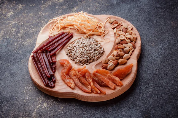 Ahşap çatal üzerinde bira için atıştırmalıklar. Dilimlenmiş balık dilimleri ve sopa şeklinde. Fındık ve peynir karışımı. Koyu dokuda yemek. Çevre dostu sofra takımı.