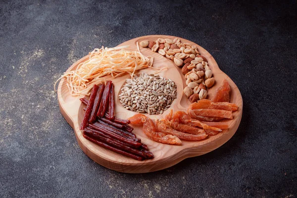 Ahşap çatal üzerinde bira için atıştırmalıklar. Dilimlenmiş balık dilimleri ve sopa şeklinde. Fındık ve peynir karışımı. Koyu dokuda yemek. Çevre dostu sofra takımı.