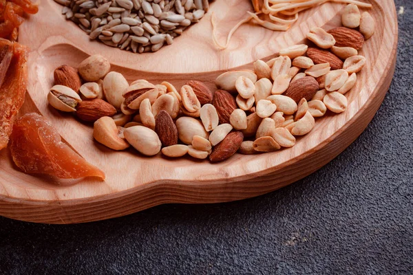 Ahşap çatal üzerinde bira için atıştırmalıklar. Dilimlenmiş balık dilimleri ve sopa şeklinde. Fındık ve peynir karışımı. Koyu dokuda yemek. Çevre dostu sofra takımı.