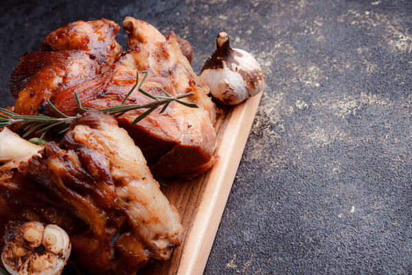 A set dish: a large fried piece of meat on the bone, country-style grilled potatoes, a mini salad of cabbage, bean sprouts, chia seeds and green onions. Original serving on a wooden cutting board.