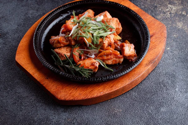 Kızarmış et ve karamelli soslu sıcak tava. Pişmiş ve taze sebzeler garnitür ve garnitür olarak..