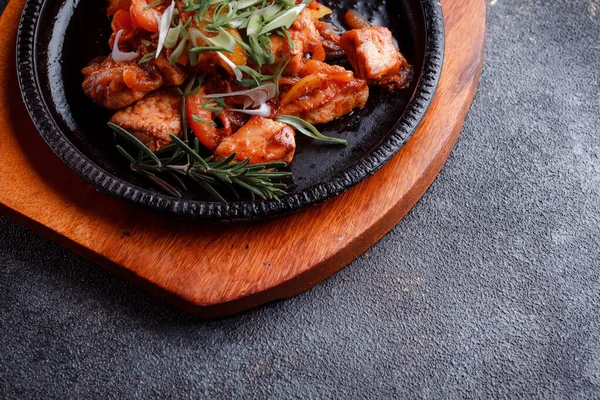 Kızarmış et ve karamelli soslu sıcak tava. Pişmiş ve taze sebzeler garnitür ve garnitür olarak..