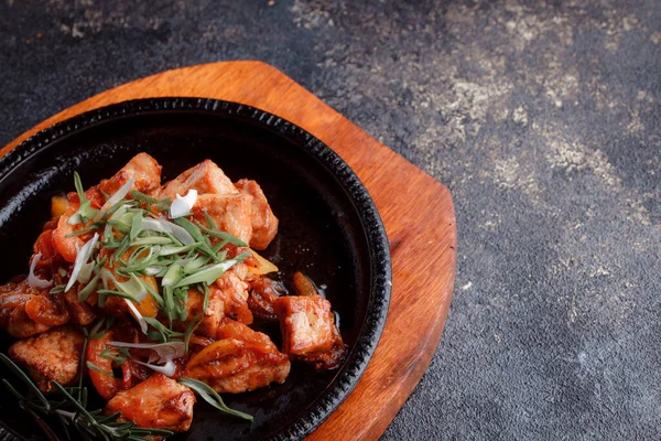 Kızarmış et ve karamelli soslu sıcak tava. Pişmiş ve taze sebzeler garnitür ve garnitür olarak..