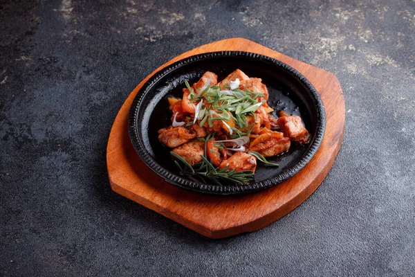 Kızarmış et ve karamelli soslu sıcak tava. Pişmiş ve taze sebzeler garnitür ve garnitür olarak..