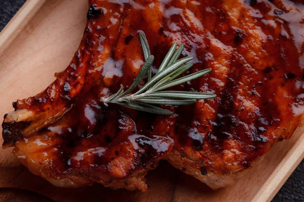 Karamelize soslu ızgara domuz bifteği. Çevre dostu ahşap kaplarda et servisi. Taze biberiye ve domates sosu..