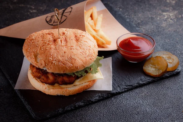 Lezzetli ev yapımı hamburger ızgara et, domates, peynir, salatalık ve ahşap masada sos..