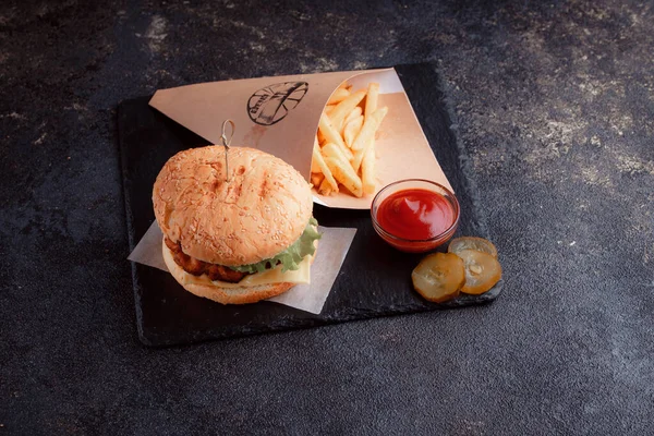Lezzetli ev yapımı hamburger ızgara et, domates, peynir, salatalık ve ahşap masada sos..