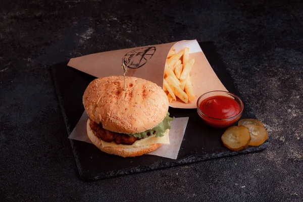 Lezzetli ev yapımı hamburger ızgara et, domates, peynir, salatalık ve ahşap masada sos..