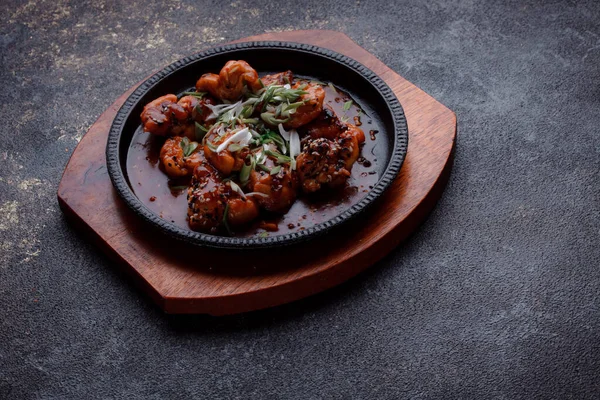 Kızarmış et ve karamelli soslu sıcak tava. Pişirilmiş ve garnitür olarak taze sebzeler. Keten tohumu ve susam tohumu eklenmiş bir yemek..