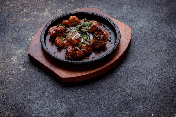 Kızarmış et ve karamelli soslu sıcak tava. Pişirilmiş ve garnitür olarak taze sebzeler. Keten tohumu ve susam tohumu eklenmiş bir yemek..