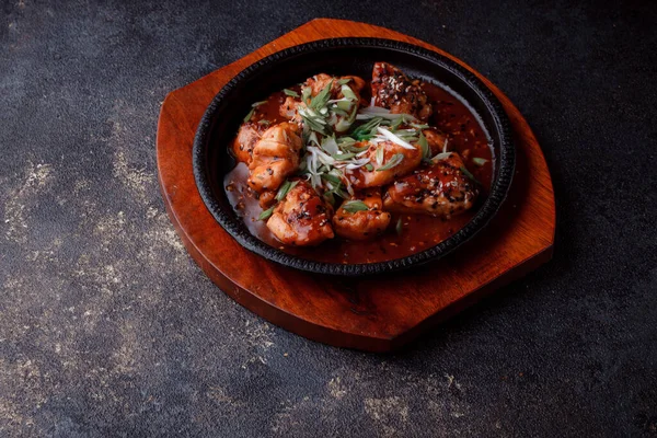 Kızarmış et ve karamelli soslu sıcak tava. Pişirilmiş ve garnitür olarak taze sebzeler. Keten tohumu ve susam tohumu eklenmiş bir yemek..