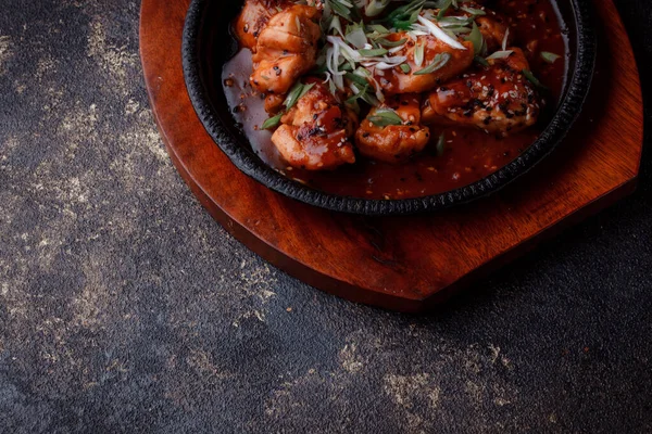 Kızarmış et ve karamelli soslu sıcak tava. Pişirilmiş ve garnitür olarak taze sebzeler. Keten tohumu ve susam tohumu eklenmiş bir yemek..